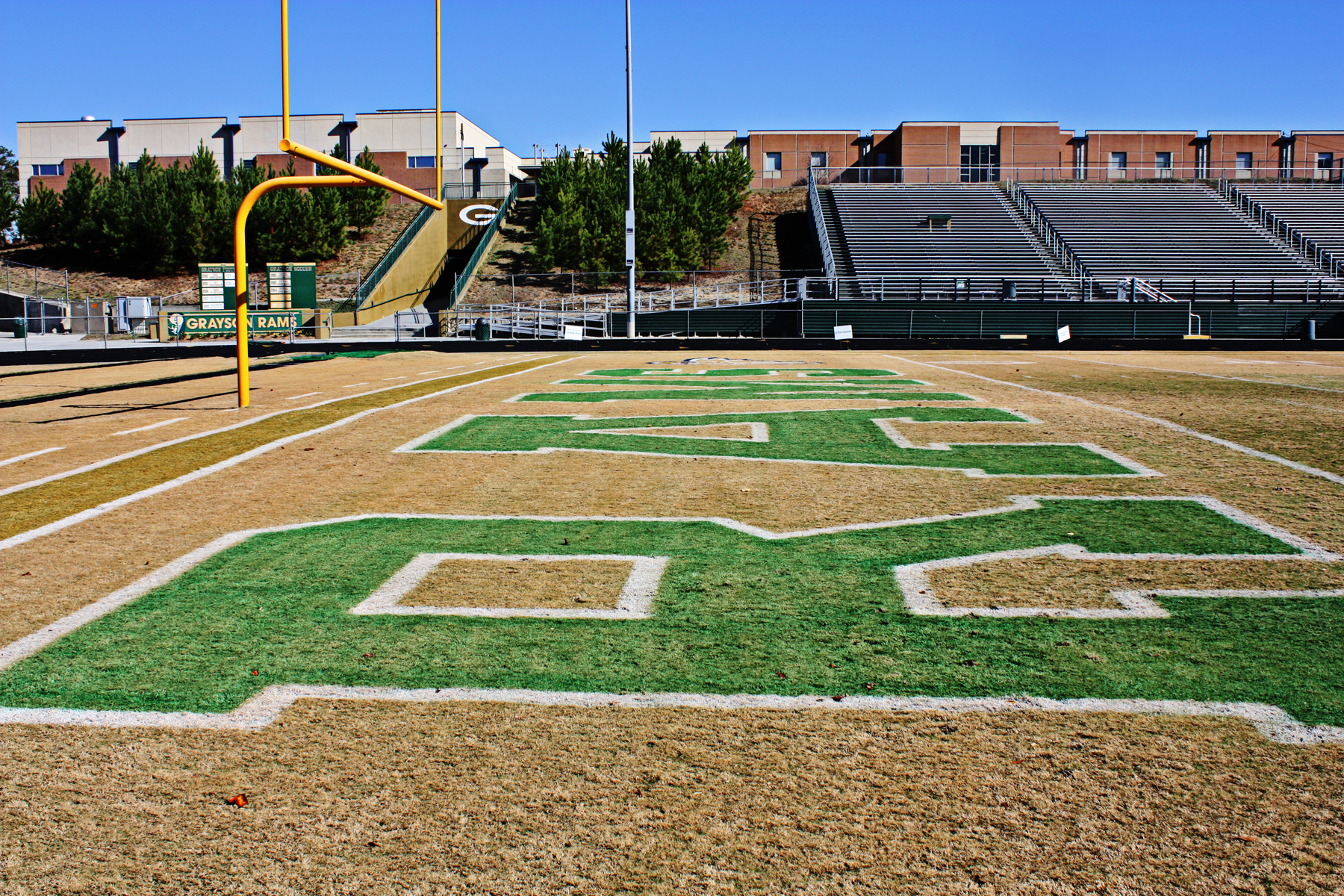Football field with "RAMS" painted on it.